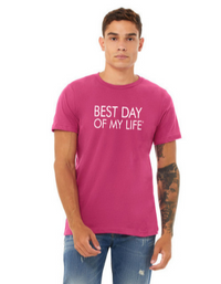 young light-brown skinned man with a half sleeve tattoo wearing a pink crewneck t-shirt with best day of my life written across in white