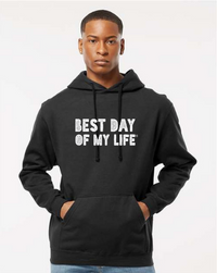 dark-skinned person with short hair wearing a black pullover hoodie with best day of my life written in white block lettering