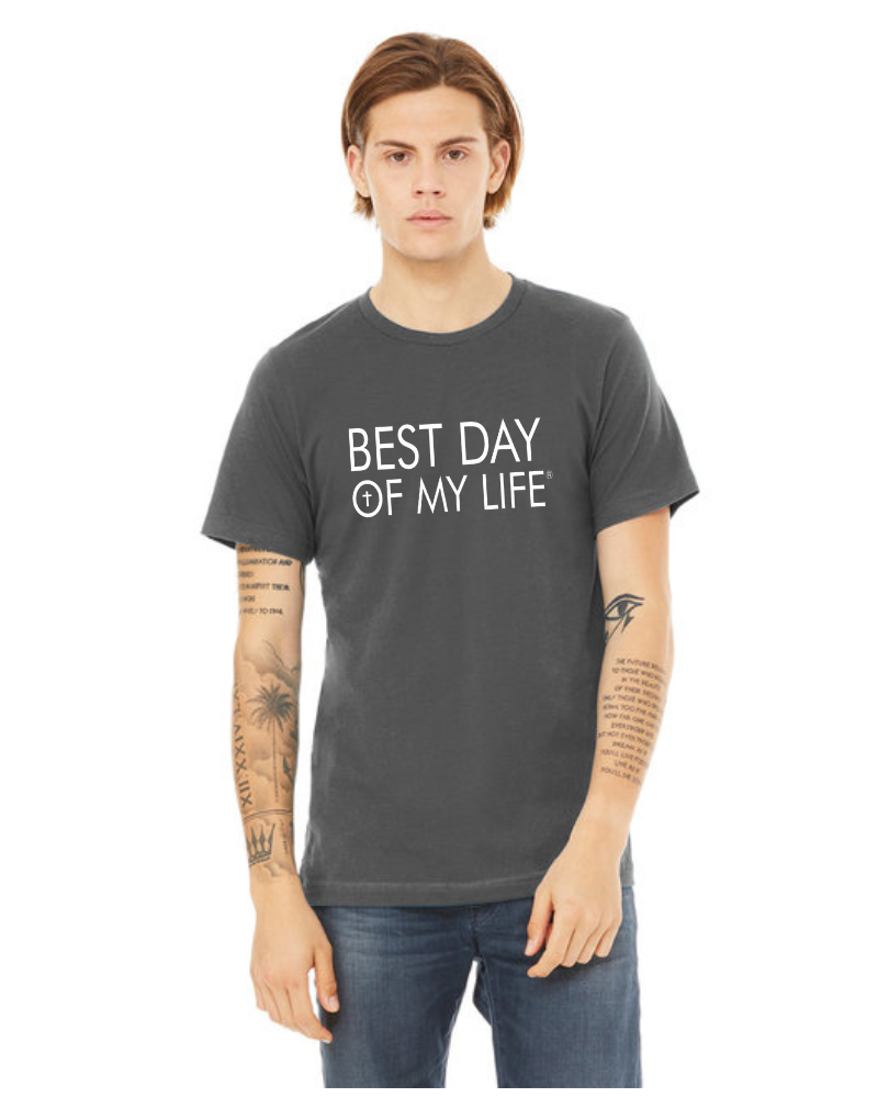 light skinned person wearing a grey crewneck t-shirt with best day of my life written in white with a cross in the O