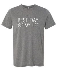 grey crewneck t-shirt with best day of my life written in white with a cross in the O