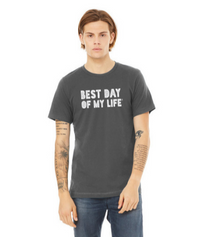 young white man wearing a grey crewneck t-shirt with best day of my life written across in white block lettering