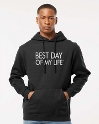 dark-skinned person with short hair wearing a black pullover hoodie with best day of my life written in white lettering