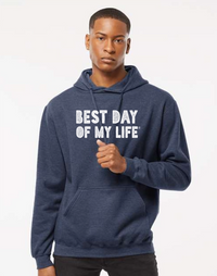 dark-skinned person with short hair wearing a blue pullover hoodie with best day of my life written in white block lettering