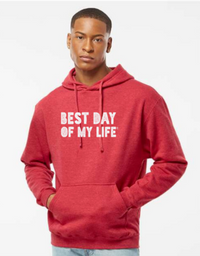 dark-skinned person with short hair wearing a red pullover hoodie with best day of my life written in white block lettering