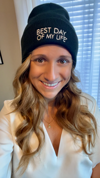 Thumbnail for white woman with blonde hair smiling and wearing black beanie embroidered with best day of my life 