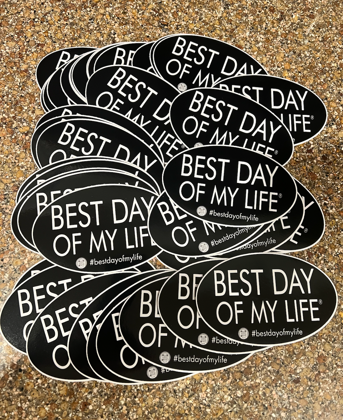 pile of black oval magnets that read best day of my life with a qr code